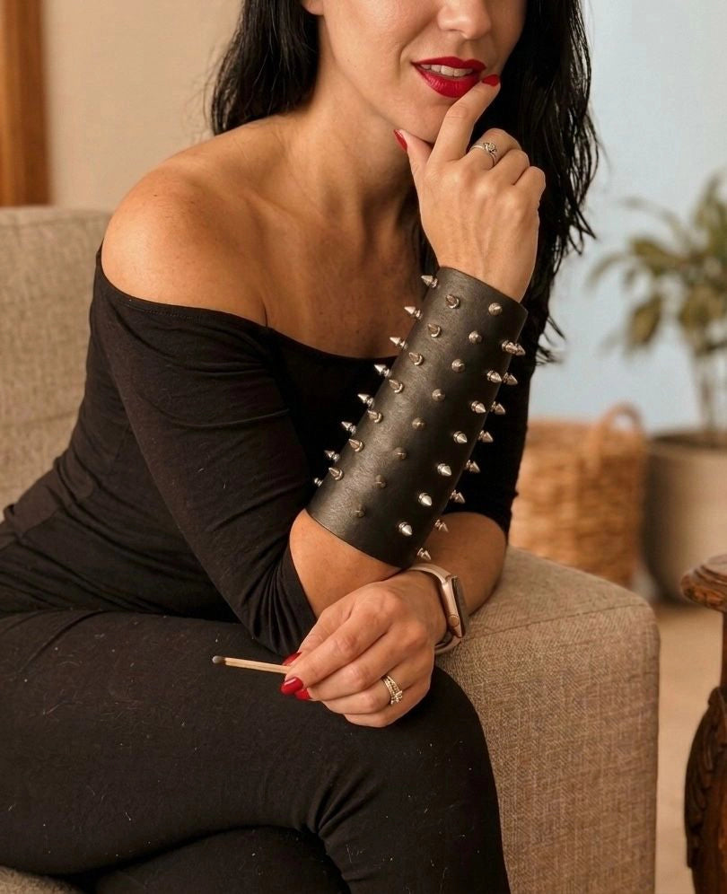 Mujer luciendo un brazalete negro de antebrazo con taches metálicos para juego de roles.